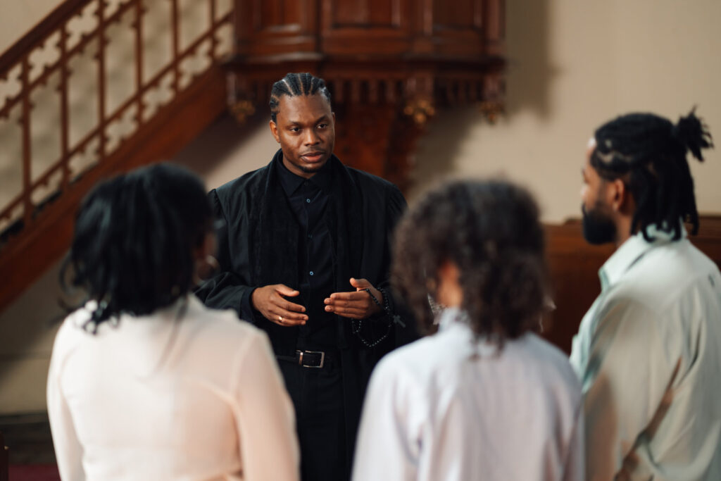 young-priest-holding-rosary-beads-talking-to-group-2026-01-09-10-34-55-utc-scaled